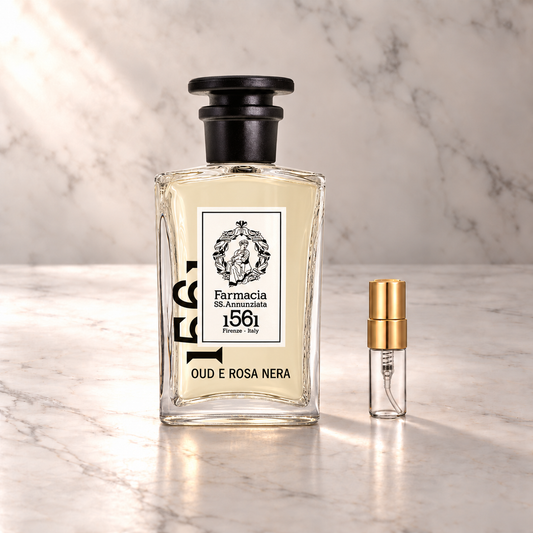 Farmacia SS.Annunziata Oud e rosa nera Eau de Parfum mit 3-ml-Duftprobe aus Glas mit Goldkappe auf hellem Marmor