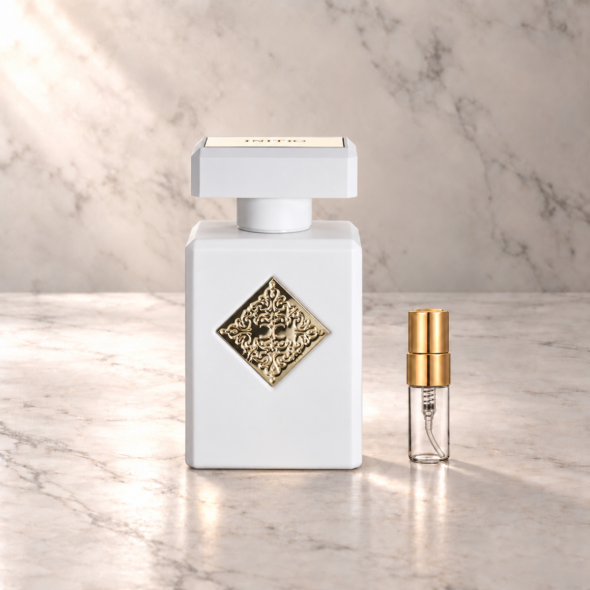 Initio Musk Therapy Extrait de Parfum mit 3-ml-Duftprobe aus Glas mit Goldkappe auf hellem Marmor