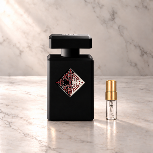 Initio Mystic Experience Eau de Parfum mit 3-ml-Duftprobe aus Glas mit Goldkappe auf hellem Marmor