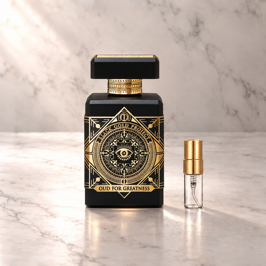 Initio Oud for Greatness Eau de Parfum mit 3-ml-Duftprobe aus Glas mit Goldkappe auf hellem Marmor