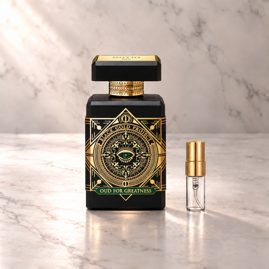 Initio Oud for Greatness NEO Eau de Parfum mit 3-ml-Duftprobe aus Glas mit Goldkappe auf hellem Marmor