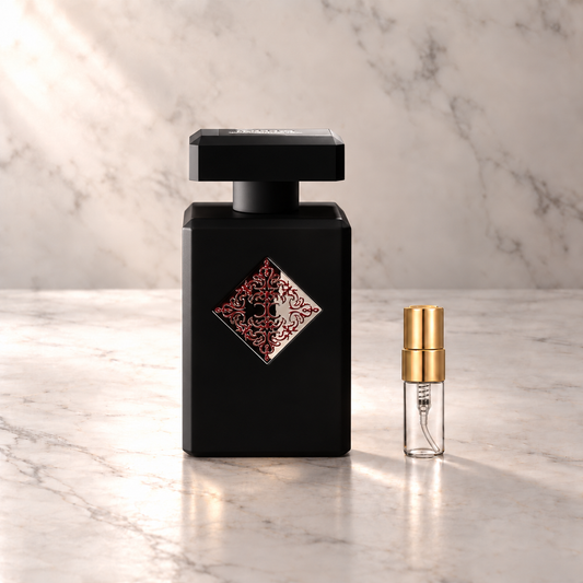 Initio Absolute Aphrodisiac Eau de Parfum mit 3-ml-Duftprobe aus Glas mit Goldkappe auf hellem Marmor