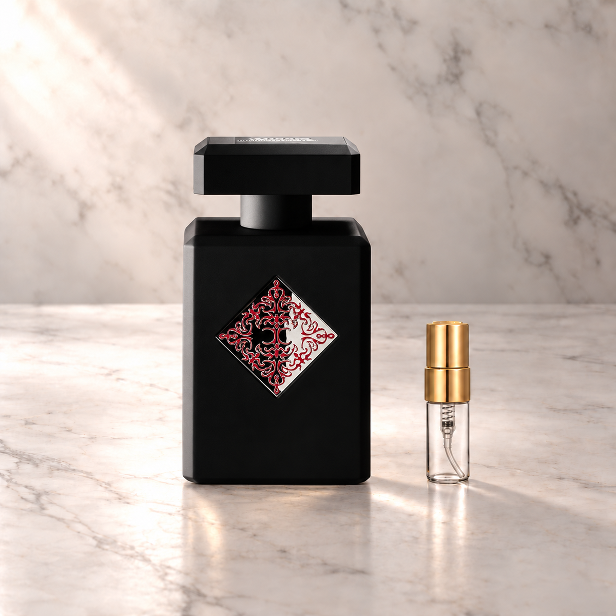 Initio Addictive Vibration Eau de Parfum mit 3-ml-Duftprobe aus Glas mit Goldkappe auf hellem Marmor