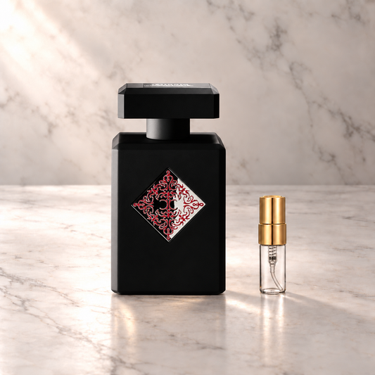 Initio Addictive Vibration Eau de Parfum mit 3-ml-Duftprobe aus Glas mit Goldkappe auf hellem Marmor