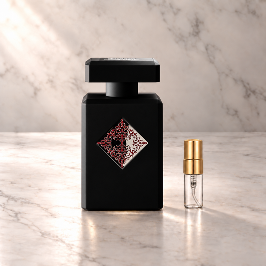 Initio Blessed Baraka Eau de Parfum mit 3-ml-Duftprobe aus Glas mit Goldkappe auf hellem Marmor