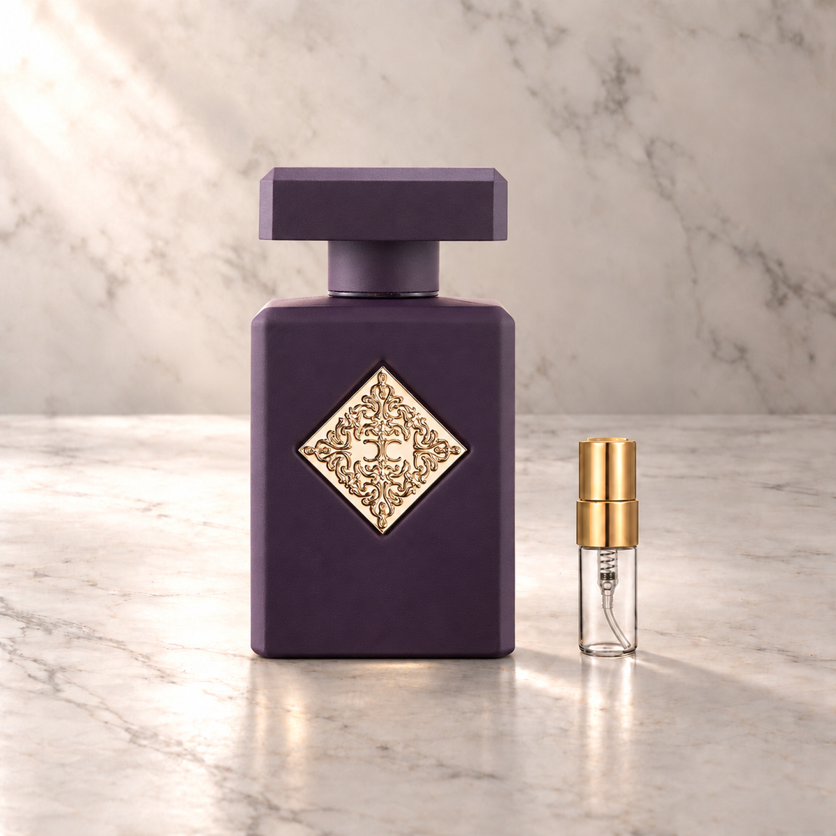 Initio High Frequency Eau de Parfum mit 3-ml-Duftprobe aus Glas mit Goldkappe auf hellem Marmor