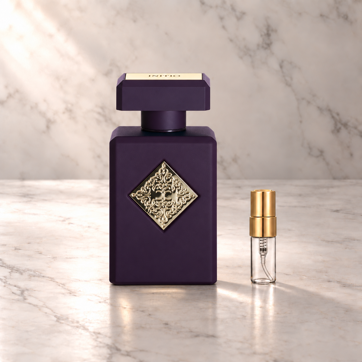 Initio Side Effect Eau de Parfum mit 3-ml-Duftprobe aus Glas mit Goldkappe auf hellem Marmor