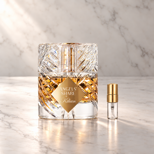 Kilian Paris Angels’ Share Eau de Parfum mit 3-ml-Glasprobe und Goldkappe auf hellem Marmor