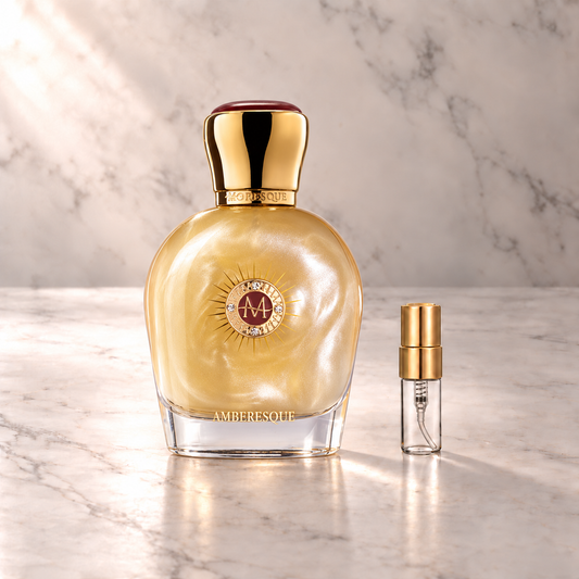 Moresque Amberesque Eau de Parfum mit 3-ml-Duftprobe aus Glas mit Goldkappe auf hellem Marmor