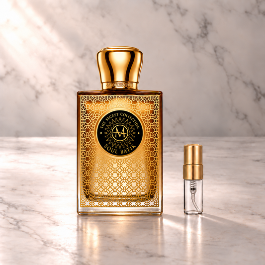 Moresque Soul Batik Eau de Parfum mit 3-ml-Duftprobe aus Glas mit Goldkappe auf hellem Marmor