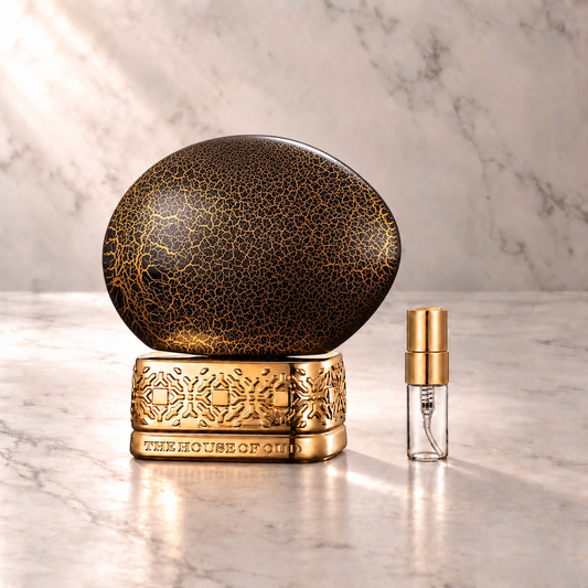 The House of Oud Blessing Silence Eau de Parfum mit 3-ml-Duftprobe aus Glas mit Goldkappe auf hellem Marmor